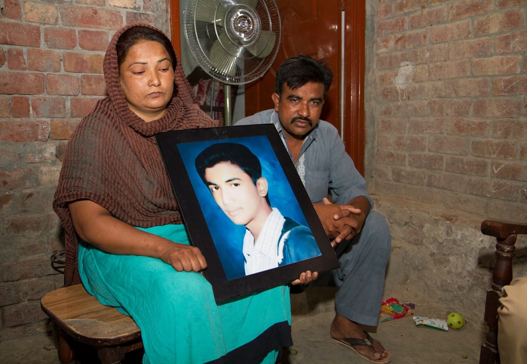 Treurende ouders met de foto van hun omgekomen zoon