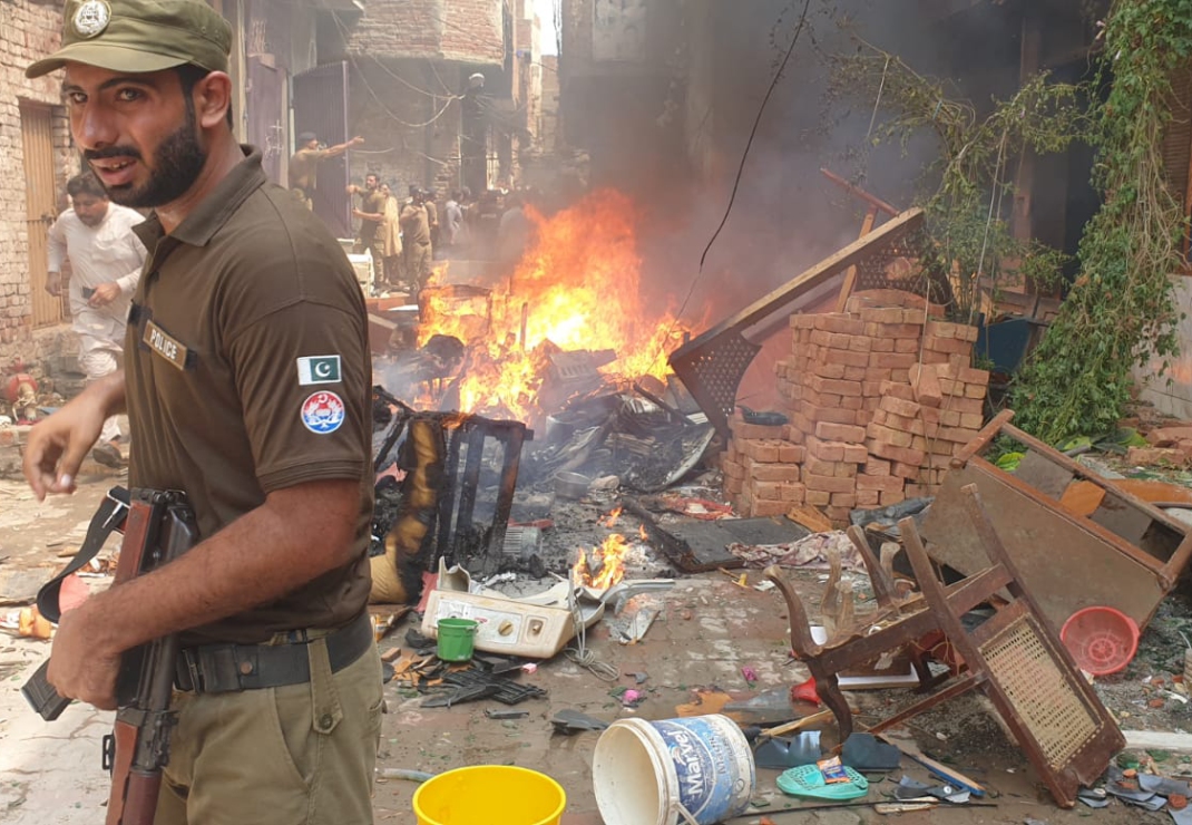 Huisraad van een christen wordt verbrand. De politie probeert de orde te herstellen