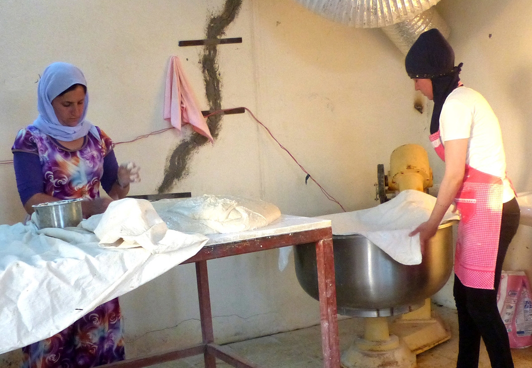 Vrijwilligsters uit het vluchtelingenkamp werken in de bakkerij