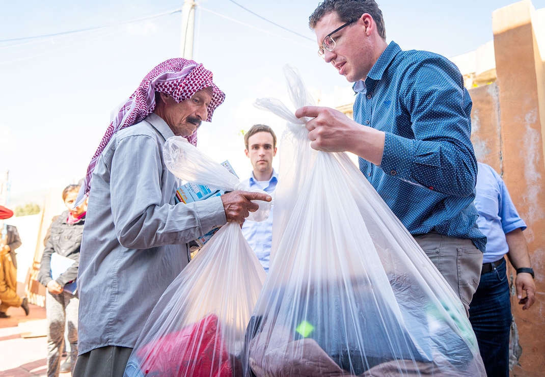 Expeditieleden delen noodhulppakketten uit. Foto: Cees van der Wal