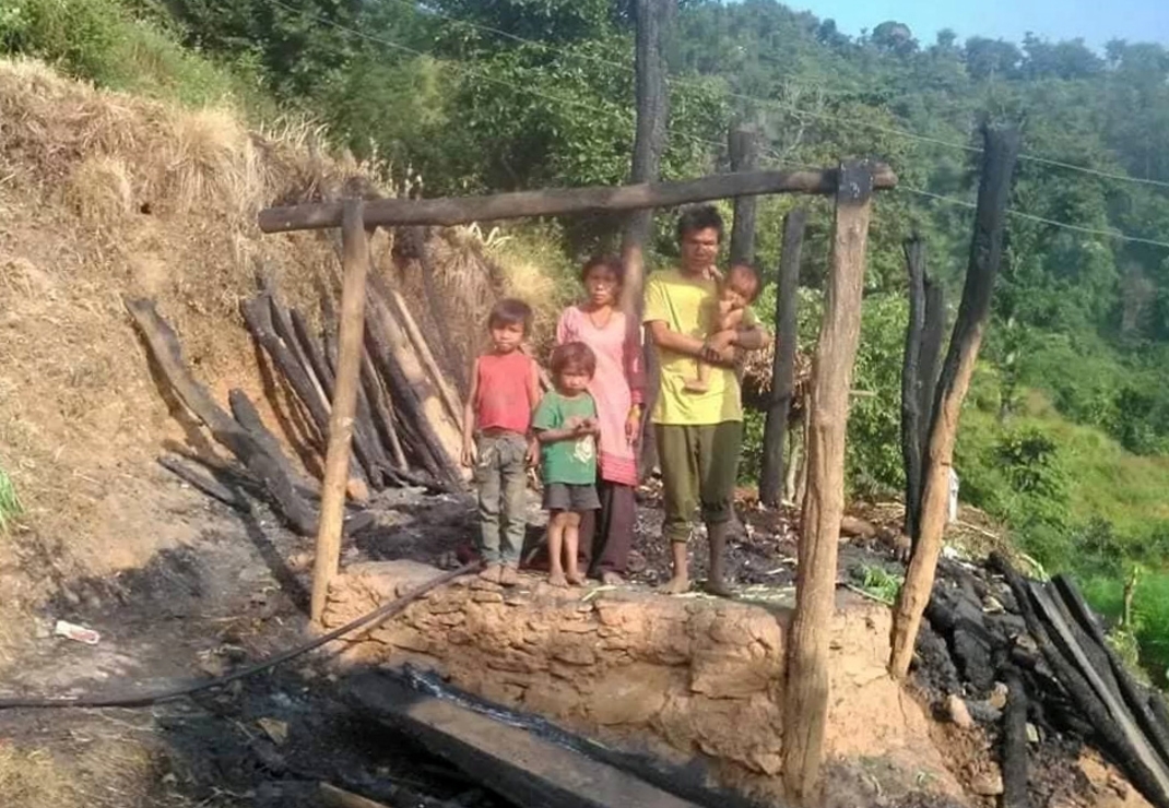 Het Chepang-gezin bij hun afgebrande huis