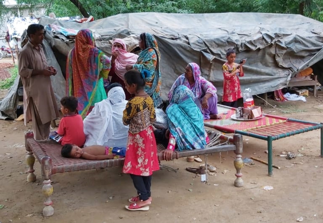 Een Pakistaanse familie schuilt in een provisorische tent van zeildoek en palen