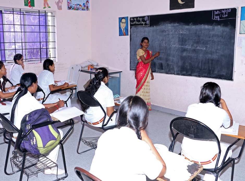 Voor de klas staat Rose, een voormalig sponsorkind. Zij geeft nu zelf les aan het MJJC in India.