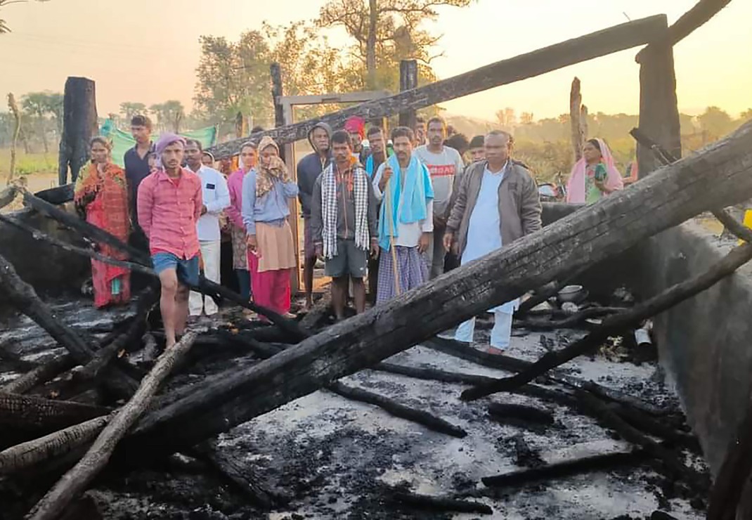 Indiase christenen tussen de verkoolde resten van hun verwoeste kerkgebouw