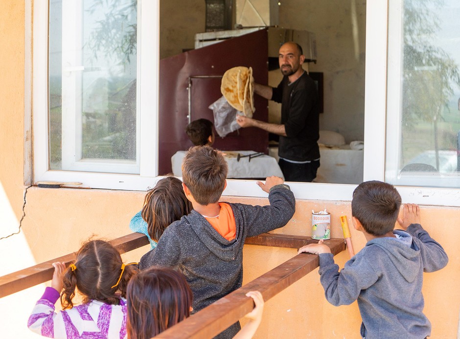 Via het uitgifteraam raam krijgen de vluchtelingen het brood
